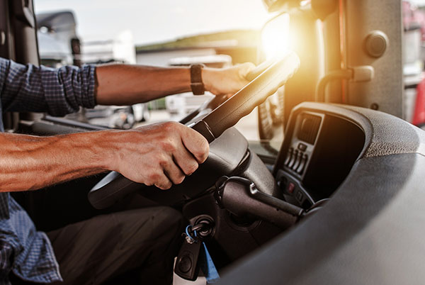 Closeup of a Man’s Hands Holding on to a Truck Steering Wheel Freight Carriers